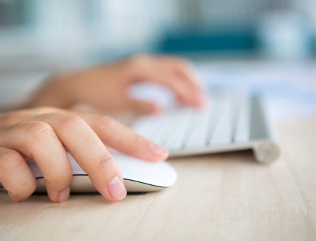 Closeup of business woman hand typing on keyboard and mouse