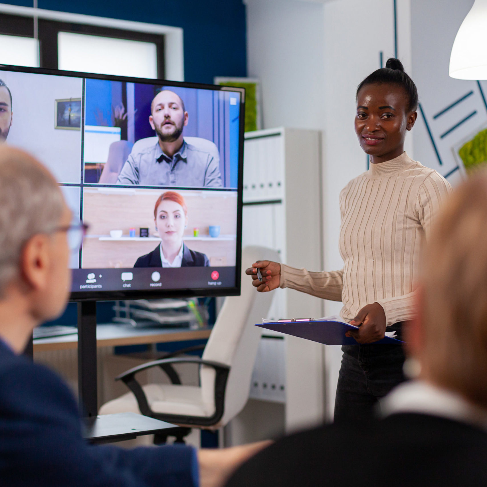 African woman discussing with remote managers on video call presenting new partners on webcam. Business people talking to webcam, do online conference participate internet brainstorming, distance office discussion.